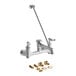 A chrome T&amp;S wall mount service sink faucet with a handle, hose, and parts.