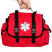 A hand holding a red Medi-First emergency bag with a white cross and text.