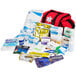 A red Medi-First emergency bag filled with first aid supplies including a medical bandage.