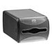 A black rectangular Tork Xpressnap countertop napkin dispenser with a clear cover.