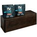 A group of bags of Hugo's chocolate chip cookies on a rectangular oak display riser.