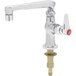 A silver T&S deck-mount faucet with a red and silver button.