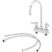 A chrome T&S deck mount faucet with a swivel gooseneck spout and hoses.