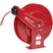 A red Reelcraft hose reel with a black hose attached.