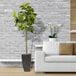 A 5' artificial fig tree in a black metal fluted planter next to a white couch.