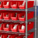 A metal shelving unit with red Regency shelf bins.