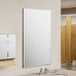 American Specialties, Inc. Plate Glass Mirror with a Stainless Steel Chan-Lok Frame above a sink in a bathroom.