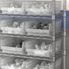 Regency clear plastic shelf bin on a metal shelving unit.