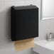 A matte black surface-mounted C-fold and multifold paper towel dispenser on a wall.