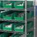 A metal shelf with a Regency green bin holding white plastic rings.