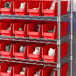 A shelf with Regency red bins and white objects inside.