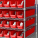 A metal shelving unit with red Regency shelf bins.