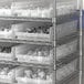 A metal shelving unit with Regency Clear plastic shelf bins.