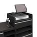 A black Econoco register well on a retail counter with a computer and a monitor.