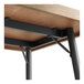 A wood table with Lancaster Table & Seating black metal bar height table base.