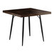 A Lancaster Table & Seating Mid-Century square wooden table with black legs and a dark wood top.