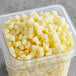 A container of IQF organic diced pineapple on a table.