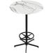 A round white marble bar table with a black base and foot rest.