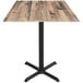 A Holland Bar Stool rustic wood square table with black metal legs.