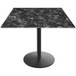 A black marble Holland Bar Stool EuroSlim table top on a round metal base.