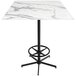 A Holland Bar Stool EuroSlim bar height table with a white marble top and foot rest base.