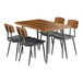 A Lancaster Table & Seating rectangular butcher block table with wooden top and metal legs with 4 black chairs with black seats.