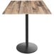 A Holland Bar Stool EuroSlim bar height table with a square rustic wood surface on a black round base.