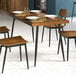 A Lancaster Table & Seating butcher block table with plates and glasses on it.