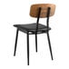 A Lancaster Table & Seating mid-century black wood chair with black vinyl seat pad.