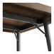A close up of the metal support for a Lancaster Table & Seating butcher block bar height table.