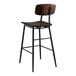 A Lancaster Table & Seating butcher block bar height table with a black metal frame and 4 matching wooden barstools.