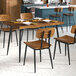 A Lancaster Table & Seating rectangular butcher block table with plates and chairs.