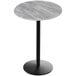 A greystone round bar height table with round black base.