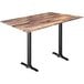 A Holland Bar Stool rustic wood table with a black metal base.