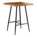 A Lancaster Table & Seating Mid-Century bar table with a wooden top and black metal legs.