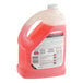 A bottle of SC Johnson Professional heavy-duty neutral floor cleaner with pink liquid inside.