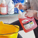 A man holding a gallon of SC Johnson Professional Heavy-Duty Neutral Floor Cleaner