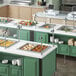 A ServIt ice-cooled drop-in food well with pans of food on a counter in a hospital cafeteria.