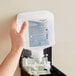 A hand holding a plastic container of SC Johnson Professional Clear Foaming Hand Soap with a label.