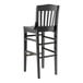 A Lancaster Table & Seating black wooden school house bar stool.
