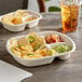 A World Centric compostable paper tray with potato chips and sauce on a table.