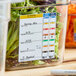 A Carlisle clear polycarbonate food pan filled with salad with a white label on it.