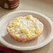 A Tony's whole grain breakfast bagel with cheese and eggs on a plate.