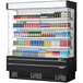 A Turbo Air black narrow depth vertical air curtain display case with drinks and beverages.