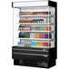 A black Turbo Air narrow depth vertical air curtain display case with drinks and beverages.