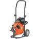 A close-up of a black and orange General Pipe Cleaners Mini-Rooter XP drain cleaning machine.