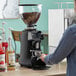 A person using a HeyCafe on-demand espresso grinder.