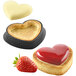A white heart shaped pastry with a strawberry on top.