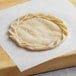 A White Toque Tarte Flambee crust on a cutting board.