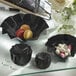 A table with black Solia Iris cardboard bowls filled with macarons.